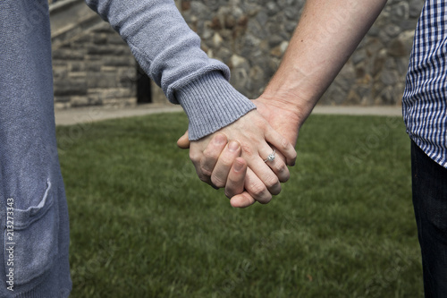 Couple holding hands with engagement ring