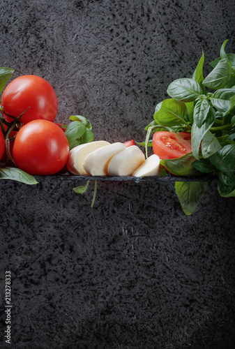Mozzarella with basil and tomatoes .