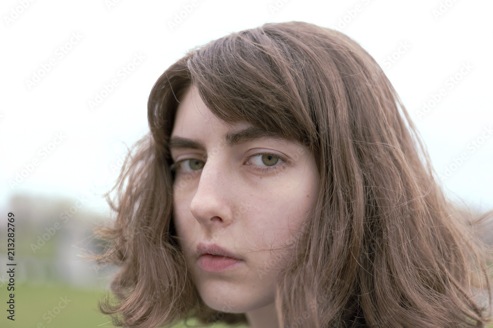 Close-up portrait of serious young woman with brown hair Close-up portrait of serious young woman with brown hair