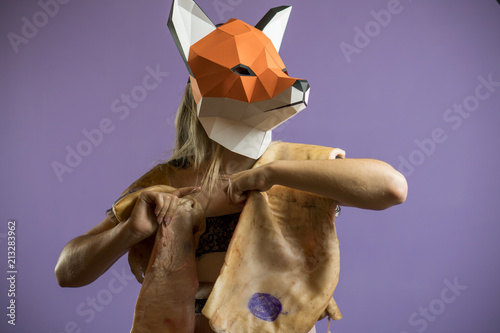 Blonde Girl in Seethrow Dress with Fox Mask paper Using Pig Skin for Covering. Dead Animal Consuming photo