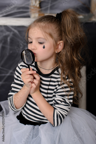  Portrait of little girl kissing magnifier.
