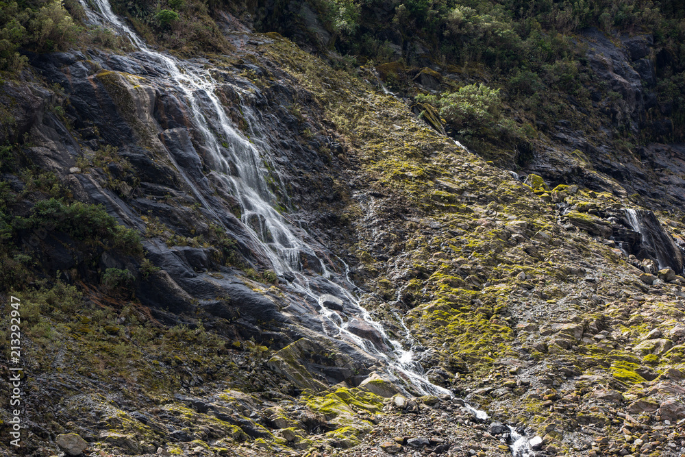 Fototapeta premium Waterfall and vegetation at Franz Josef Glacier, south island New Zealand