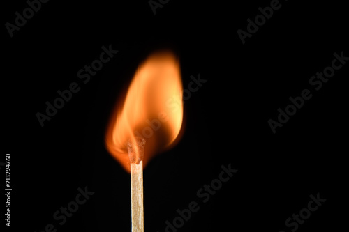 Match with strongly and evenly burning flame on a black background closeup