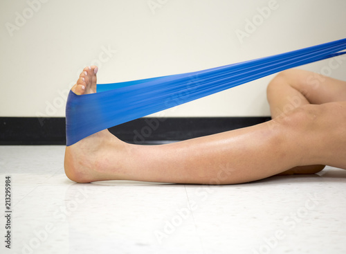 Young Female using a resistance band for ankle exercises in the gym