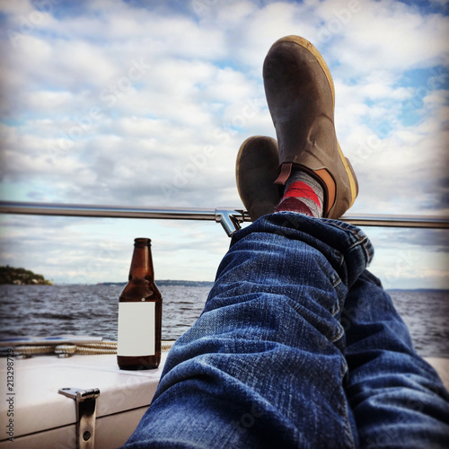 Man with feet up on boat relaxing with a beer