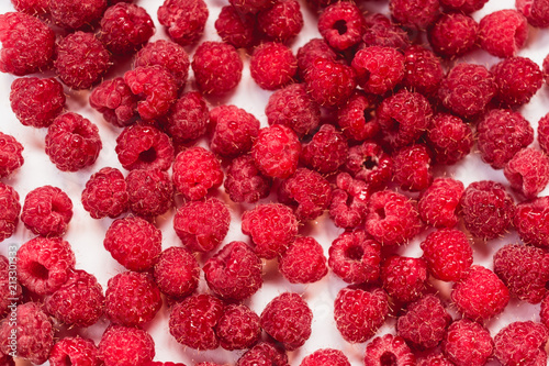 Dripping raspberry on white background. photo