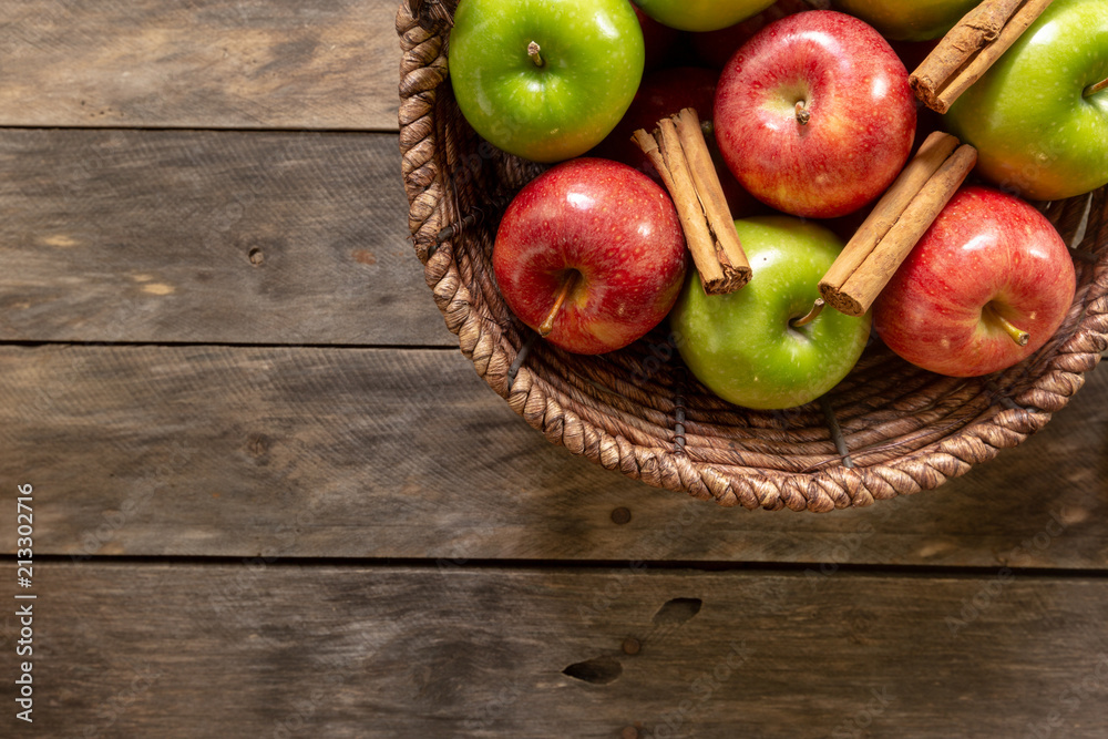 Apples red and green on rustic wooden table in basket Apples red and green on rustic wooden table in basket