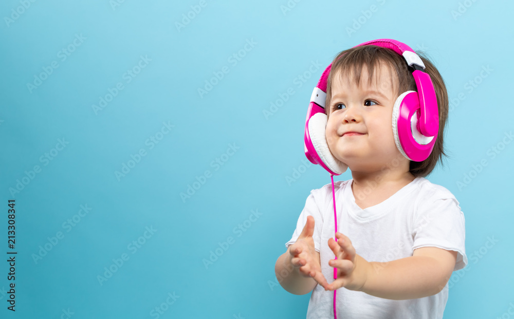 Toddler boy with headphones on a blue background