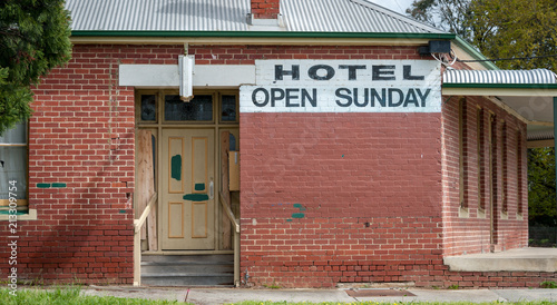 Old and closed rural hotel with sign reading Hotel Open Sunday