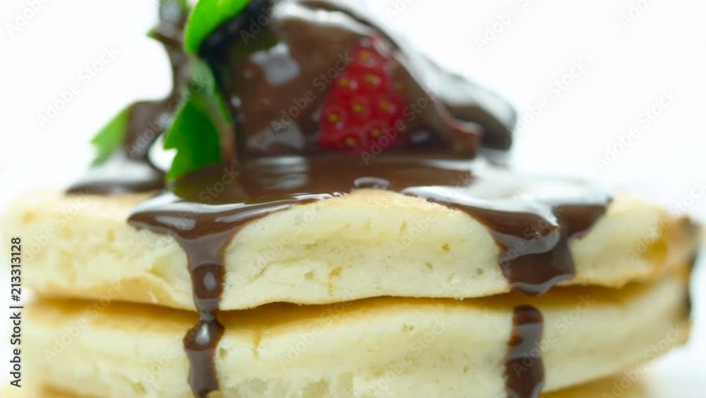 Stack of pancakes with strawberry and drizzled with chocolate sauce, macro closeup. Stack of pancakes with strawberry and drizzled with chocolate sauce, macro closeup.