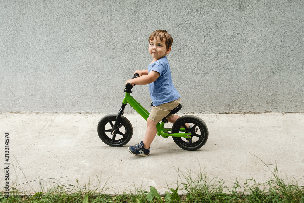 Happy boy riding a small bicycle in the park Happy boy riding a small bicycle in the park