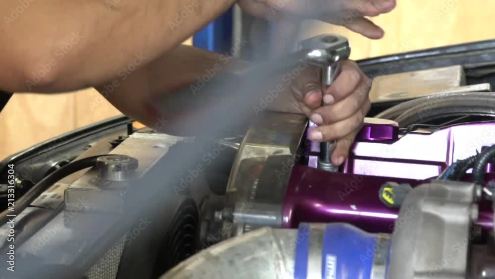 Hand working in a car engine Hand working in a car engine