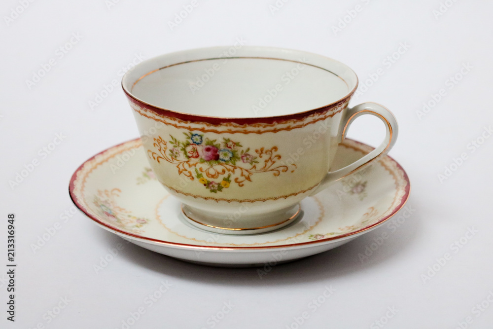 An isolated porcelain cup in a saucer An isolated porcelain cup in a saucer
