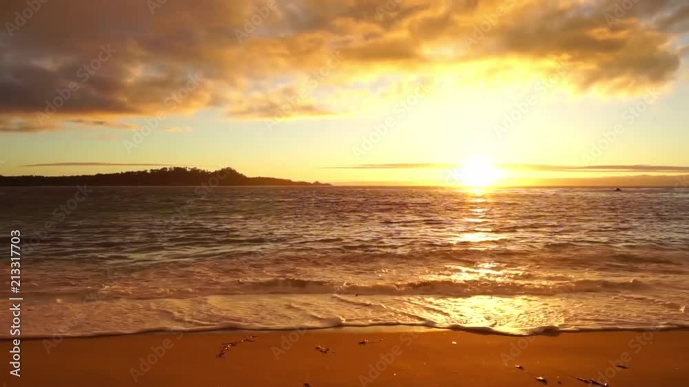 A beautiful sunset on the coast of California with the waves crashing on the colorful sand. A beautiful sunset on the coast of California with the waves crashing on the colorful sand.