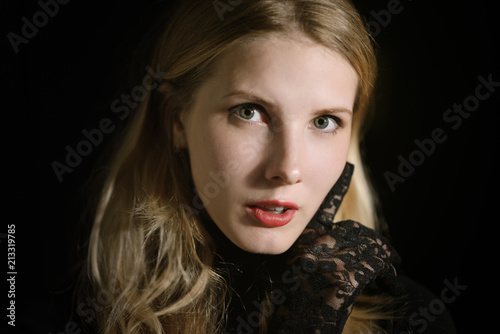 Portrait of beautiful young woman on dark background.