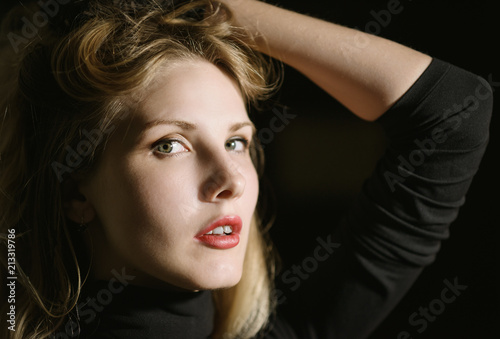 Portrait of beautiful young woman on dark background.