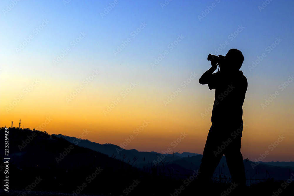 Silhouette of a photographer taking photo with sunset.