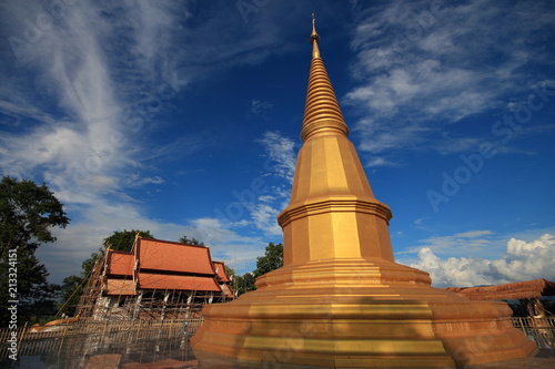 Northern Thai Buddhist temple gable roof architectural ornamental details. delicate religious art work details against clear blue sky background.