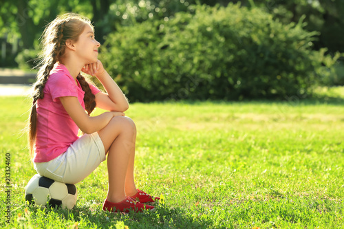 Cute girl sitting on soccer...