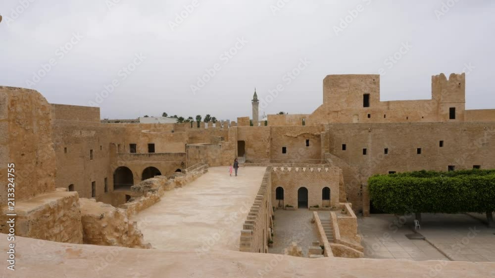 View inside of ancient fortress Ribat of Monastir with trees and walking tourists, Tunisia View inside of ancient fortress Ribat of Monastir with trees and walking tourists, Tunisia