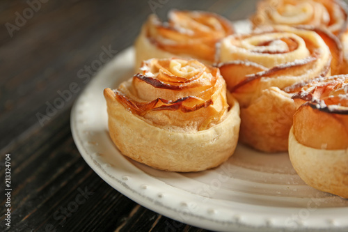 Plate with apple roses from puff pastry on table, closeup