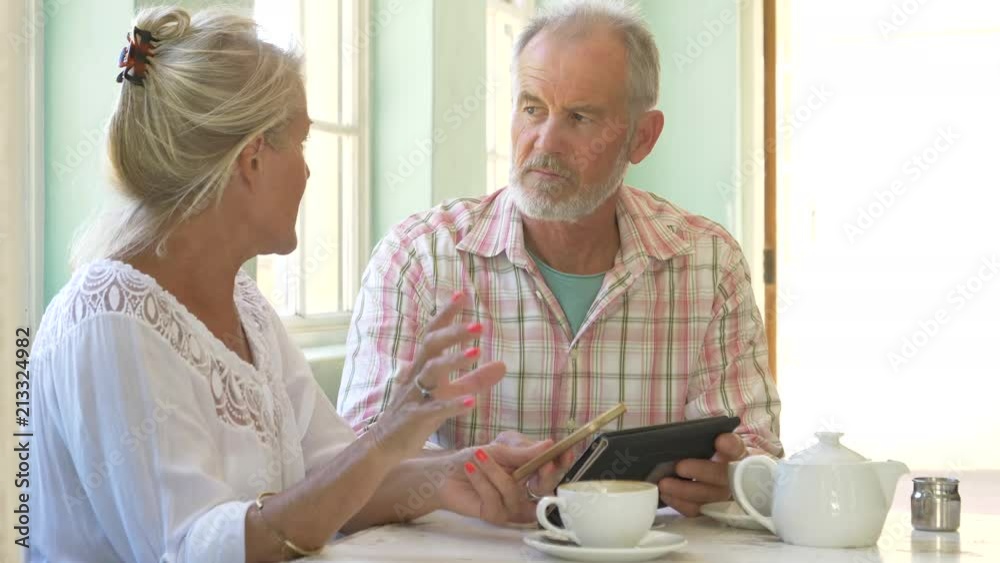 Mature couple sitting together having coffee in a cafe Mature couple sitting together having coffee in a cafe