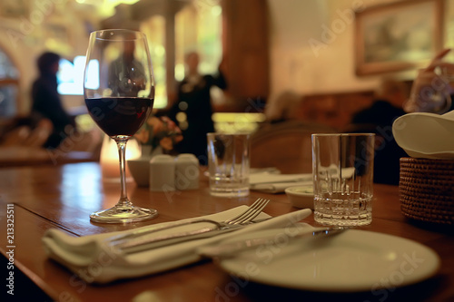red wine glass serving / romantic dinner in the interior of the restaurant, a table served with a glass of grapes wine