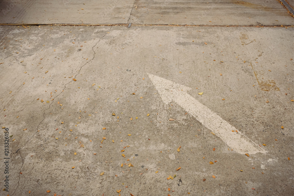 Fototapeta premium White Arrow signs and symbols on concrete road in the parking area.