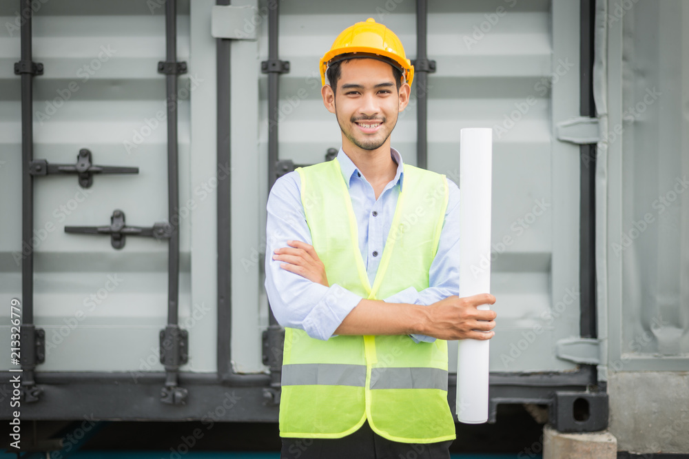 engineer holding blueprint and standing at construction site area. he smile after construction complete. engineer holding blueprint and standing at construction site area. he smile after construction complete.