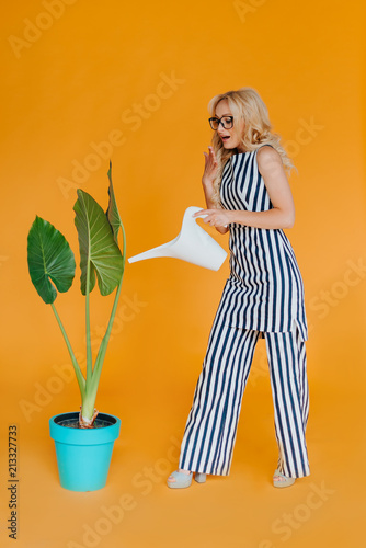 business lady dressed in suit.female with red lips and glasses.Care for plants