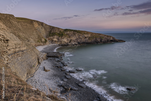 Pebble beach and cliffs, as seen from the Welsh Coastal Path, in south Wales, UK