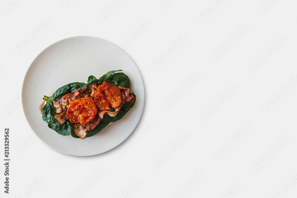 Delicious and nutritious toast or sandwich with bacon, spinach and tomato. Tasty food. Nearby place for text Delicious and nutritious toast or sandwich with bacon, spinach and tomato. Tasty food. Nearby place for text