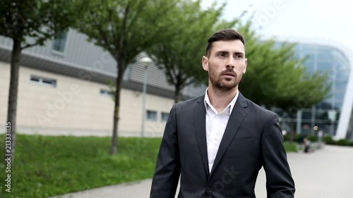 Wallpaper Mural Young Handsome Businessman Walking in the Streets. Wearing Official Suit. Looking at the Camera. Huge Glass Building in the Background. Successful Lifestyle. Office Worker. Torontodigital.ca