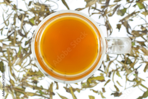 tea in glass cup and dried leaves