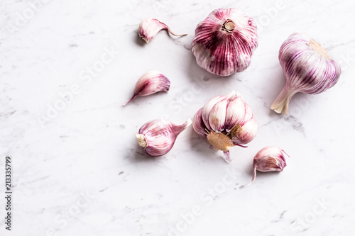 Garlic Cloves and Bulbs on white marble board