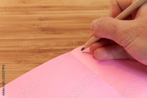 Writing in a pink notebook