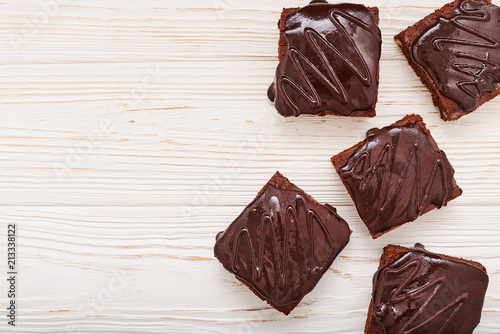 homemade chocolate brownies on white wooden background, top view