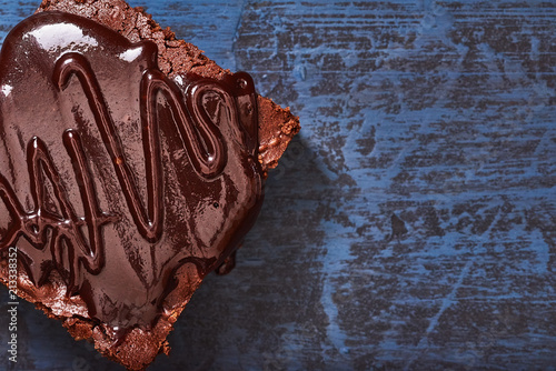 homemade chocolate brownies on dark blue background, top view