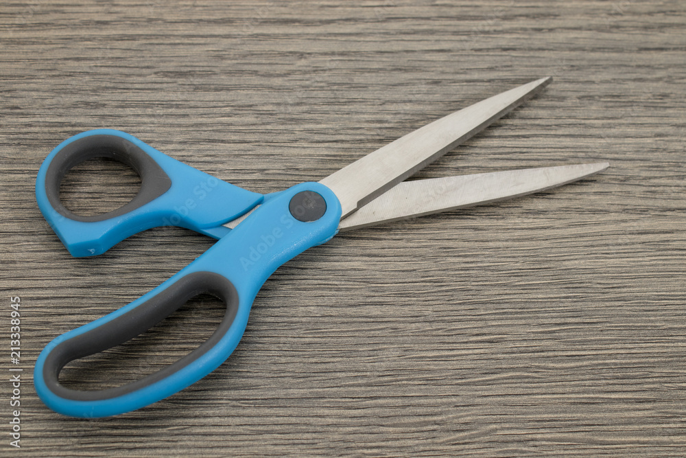 Metal blue scissors on a decorated wood table Metal blue scissors on a decorated wood table