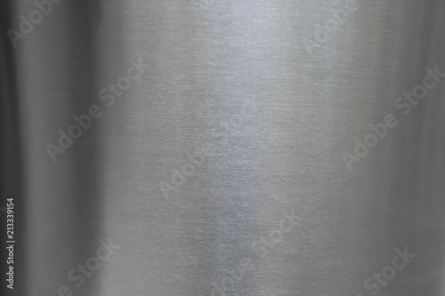 Close up industrial background of fractally scratched diagonal circular lines to silver metal stainless steel surface. Creative lighting detail macro photography. photo