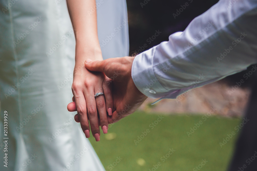 Bride and groom holding hands in wedding celemony.