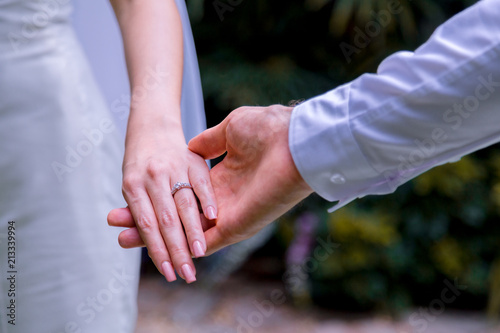 Bride and groom holding hands in wedding celemony.