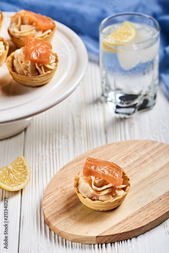 tartlets with mascarpone and red fish on a wooden table
