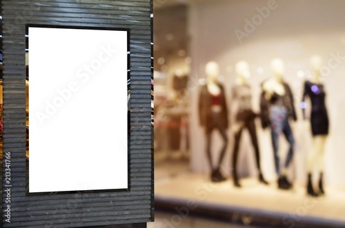 blank billboard or advertising light box for your text message or media content with blurred image of fashion clothes shop showcase in shopping mall, commercial, marketing and advertisement concept