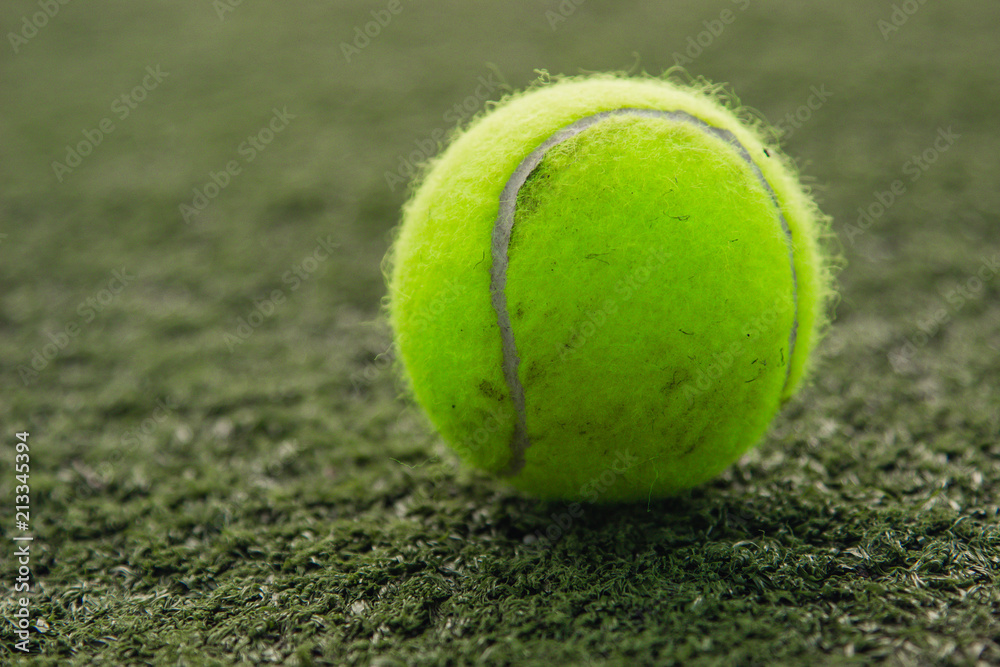 Tennis ball lies on the grass