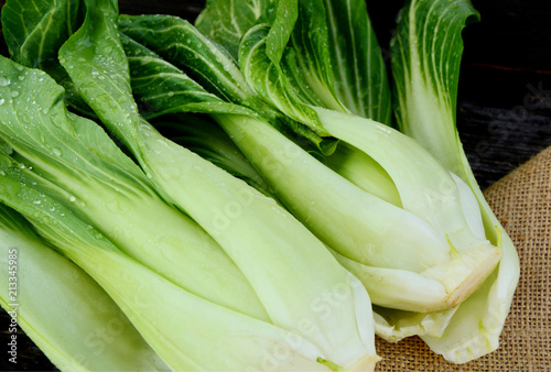 Fresh Bok choy or pak choi and water drop on wooden background and sack cloth.
Pak choi are high Vitamin C,K and Calcium  keep our bones healthy and maintained.