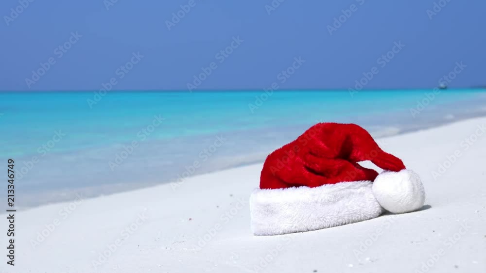 Christmas helper hat on tropical sandy beach with calm waves. Maldivian destination Christmas helper hat on tropical sandy beach with calm waves. Maldivian destination