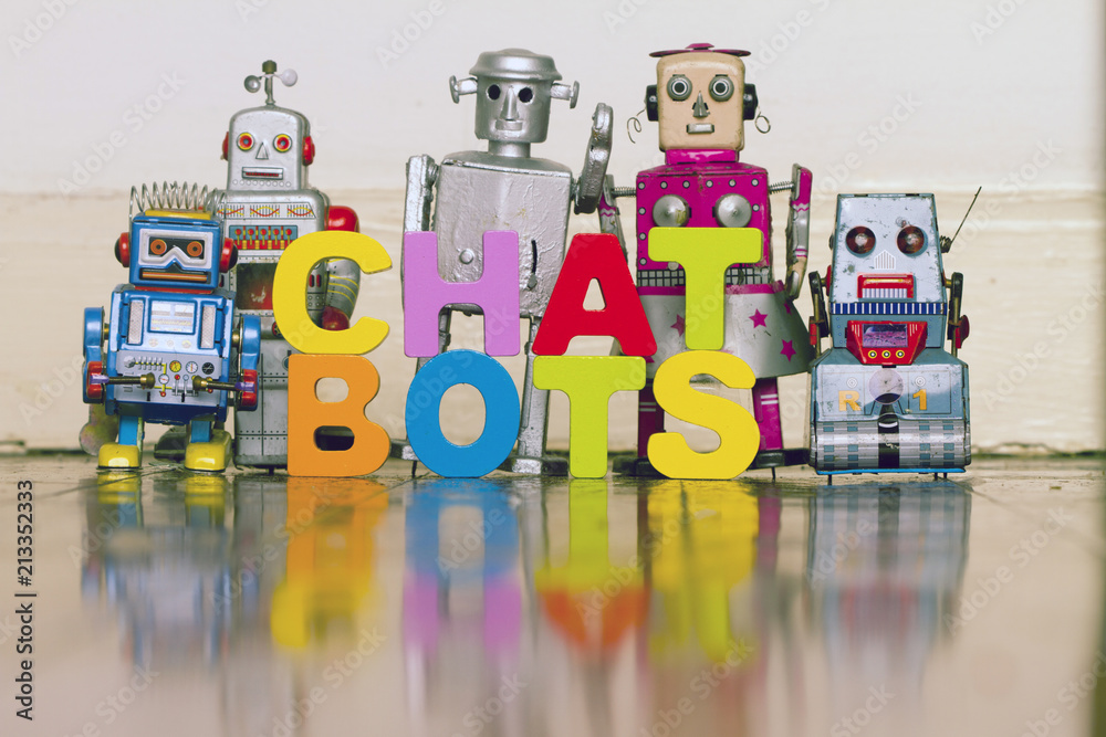 Obraz premium the word CHAT BOTS with5 retro robots on a wooden floor