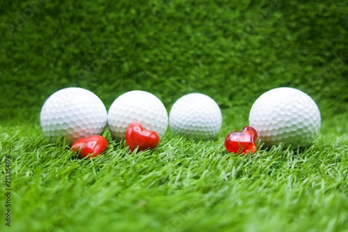 Golf ball with heart shape for golfer lover are on green grass