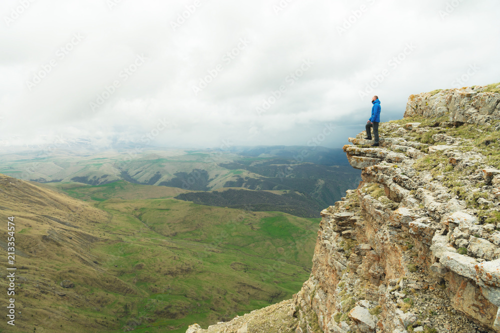 bearded hipster tourist man standing on the edge of a rock and looking out into the distance on an epic plateau. The concept of tourism bearded hipster tourist man standing on the edge of a rock and looking out into the distance on an epic plateau. The concept of tourism
